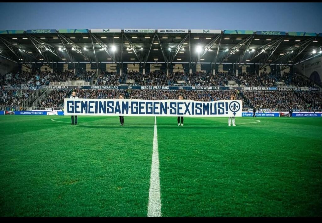 Banner auf dem Spielfeld: Gemeinsam gegen Sexismus!